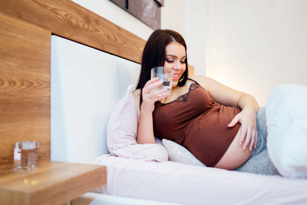 Pregnant woman staying hydrated and drinking plenty fluids